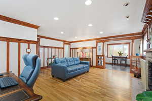 Living room featuring ornamental molding and light wood-type flooring