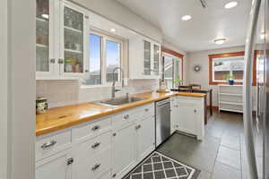 Kitchen featuring white cabinetry, sink, a healthy amount of sunlight, and stainless steel dishwasher