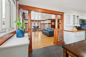 Kitchen featuring decorative columns, white cabinetry, stainless steel appliances, and dark hardwood / wood-style floors