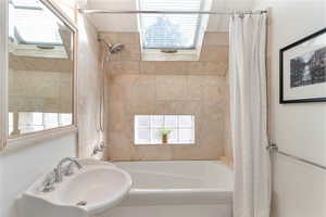 Full Bathroom with plenty of natural light, shower / bathtub combination, with skylight.