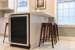 Kitchen island with wine cooler and seating.