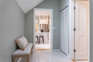 Hallway featuring vaulted ceiling next to family room, laundry and 3/4 bath.