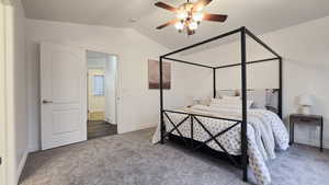 Bedroom featuring ceiling fan, dark carpet, and vaulted ceiling