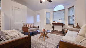 Living room with ceiling fan and dark hardwood / wood-style floors