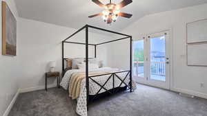 Bedroom with access to exterior, dark colored carpet, vaulted ceiling, and ceiling fan