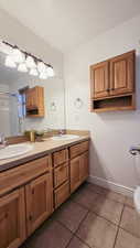 Bathroom featuring tile patterned floors, vanity, toilet, and a shower