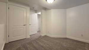 Carpeted empty room with a textured ceiling