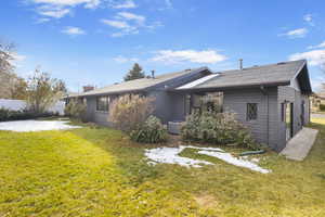 Rear view of property with a yard and cooling unit