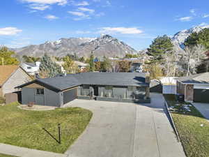 Single story home with a mountain view, a garage, and a front yard