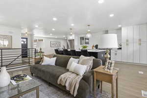 Living room with a textured ceiling, light hardwood / wood-style flooring, and crown molding