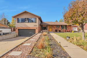 Split level home with a garage and a front lawn