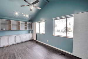 Unfurnished room with beamed ceiling, hardwood / wood-style floors, plenty of natural light, and ceiling fan