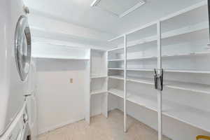 Pantry featuring stacked washer / drying machine