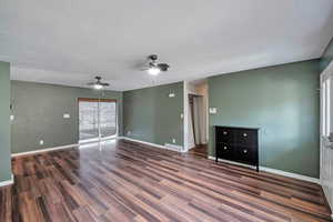 Empty room featuring a textured ceiling, ceiling fan, and dark wood-type flooring