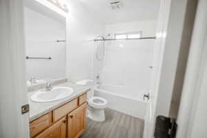 Full bathroom with vanity, tile flooring, toilet, and shower / washtub combination