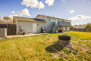 Back of house featuring a yard, a patio area, and a wooden deck