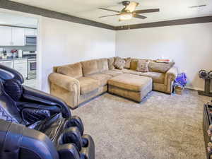 Living room view 3 featuring ceiling fan and light carpet. views of mountains