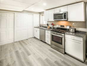 MIL/Apt New Kitchen featuring white cabinets, LVP flooring, sink, and appliances with stainless steel