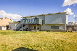 Rear view of property featuring a patio area, a deck, a yard, and a storage shed