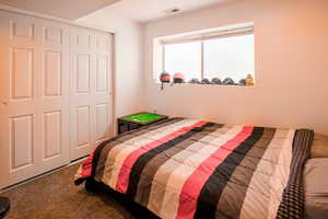 1st of 2 downstairs or apartment Bedroom. One of four total featuring carpet floors and a closet