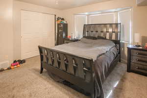 Primary Bedroom with a bay window, double closet and carpet floors