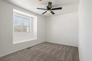 Carpeted spare room featuring a textured ceiling and ceiling fan