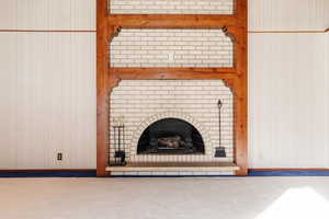 Interior details with a brick fireplace and wooden walls