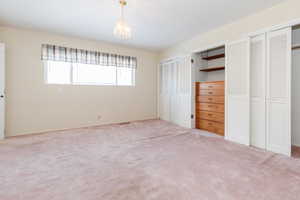 Unfurnished bedroom with multiple closets and light colored carpet