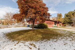 View of front of home with a yard and a garage