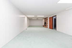 Unfurnished room with carpet flooring and a fireplace