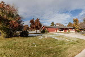 Ranch-style house with a front yard and a garage