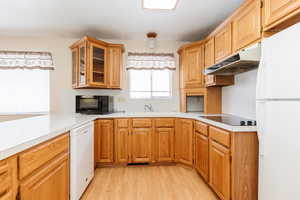 Kitchen featuring sink, light hardwood / wood-style floors, and white appliances