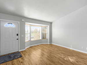 Foyer entrance with a textured ceiling and light hardwood / wood-style flooring