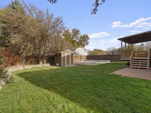 View of yard featuring a wooden deck and a storage shed