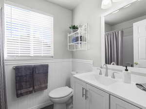 Bathroom with a shower with curtain, vanity, and toilet