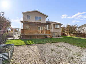 Back of house with a pergola, a yard, and a deck