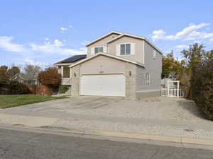 Front of property featuring solar panels and a garage