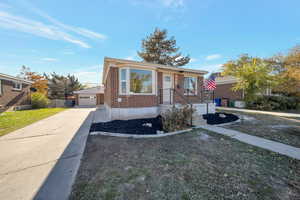 Bungalow-style home featuring a garage, an outdoor structure, and a front lawn