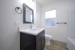 Bathroom featuring hardwood / wood-style floors, vanity, and toilet