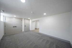 Interior space featuring carpet and a textured ceiling