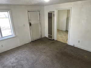 Unfurnished bedroom with carpet flooring and a textured ceiling