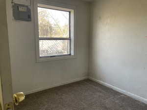 Carpeted empty room with electric panel