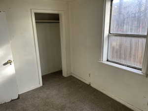 Unfurnished bedroom with a closet and carpet floors