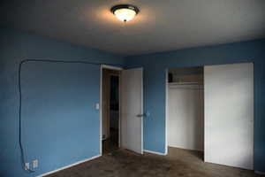 Unfurnished bedroom with dark colored carpet and a closet