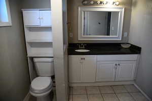 Bathroom with tile patterned flooring, vanity, and toilet