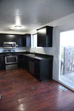 Kitchen featuring stainless steel appliances, dark hardwood / wood-style floors, and sink