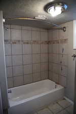 Bathroom featuring tile patterned floors and tiled shower / bath combo