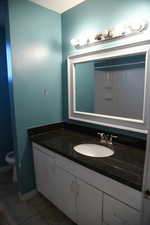 Bathroom featuring tile patterned flooring, vanity, and toilet