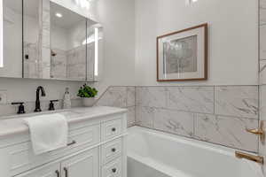 Bathroom featuring a bathing tub and vanity