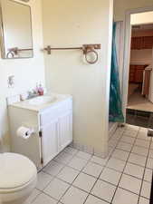 Bathroom with tile patterned flooring, vanity, toilet, and a shower with curtain